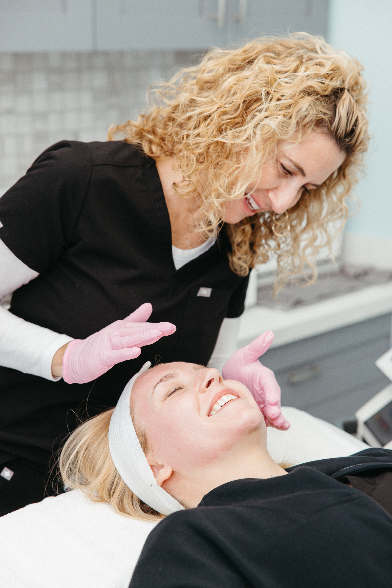 Beautiful young girl smiles with a medical assistant during MOXI Laser Treatment